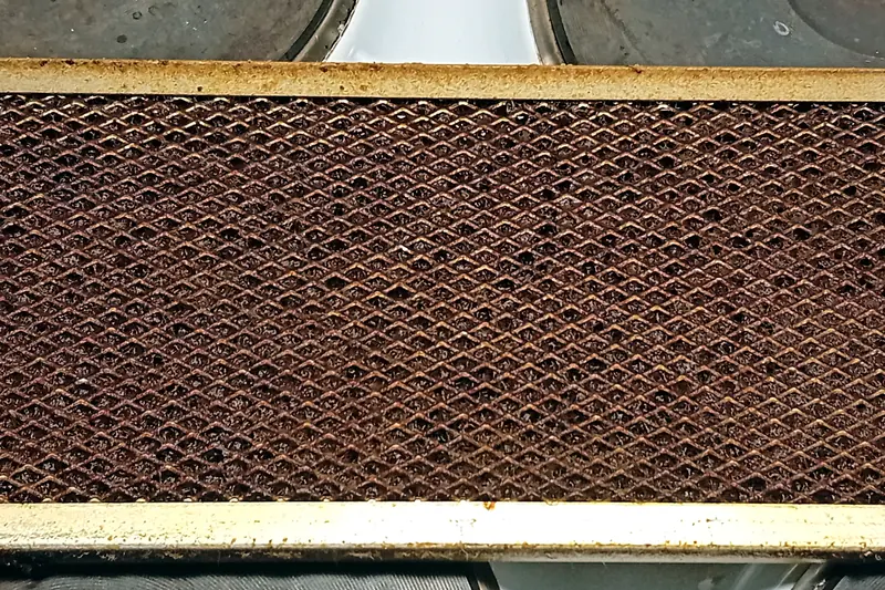 Old aluminum mesh range hood filter caked with dark brown grease